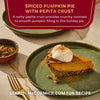 A slice of McCormick Spiced Pumpkin Pie with Pepita Crust topped with whipped cream is displayed on a green plate.