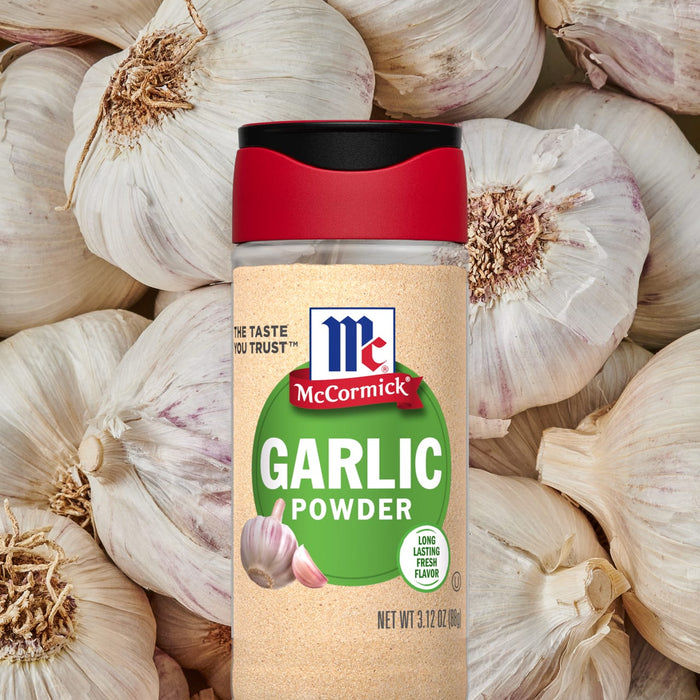 A jar of McCormick Garlic Powder is surrounded by garlic cloves.