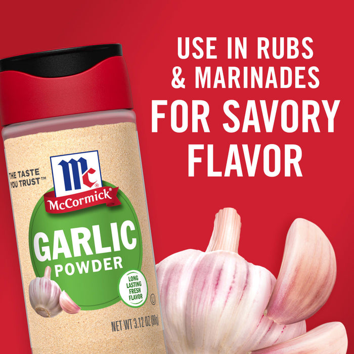 A jar of McCormick Garlic Powder with fresh garlic cloves.