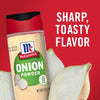 A container of McCormick Onion Powder with a white onion in the background.