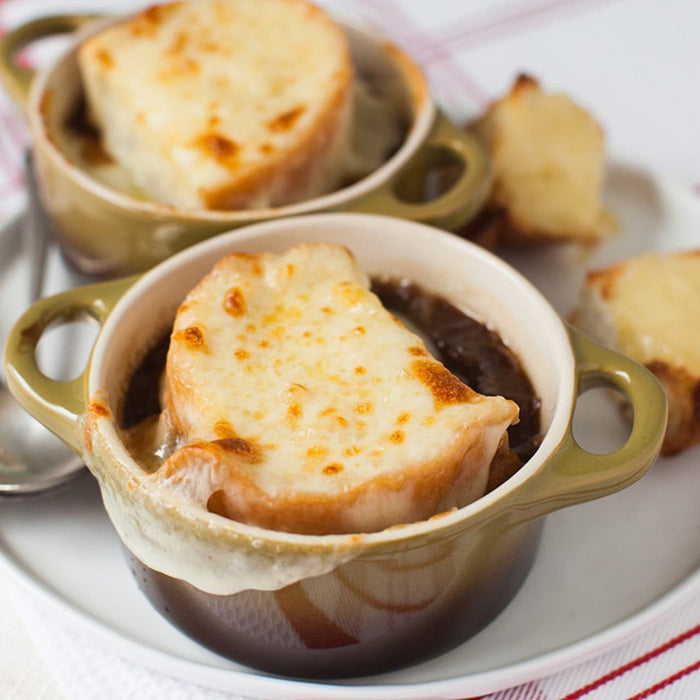 Two bowls of French onion soup with toasted bread topped with melted cheese.