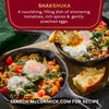 A close-up of two cast iron skillets filled with McCormick Shakshuka, a nourishing dish of simmering tomatoes, rich spices, and gently poached eggs.