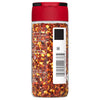 A glass jar of McCormick Crushed Red Pepper.