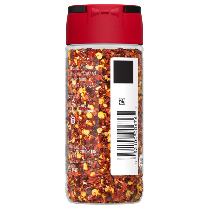 A glass jar of McCormick Crushed Red Pepper.