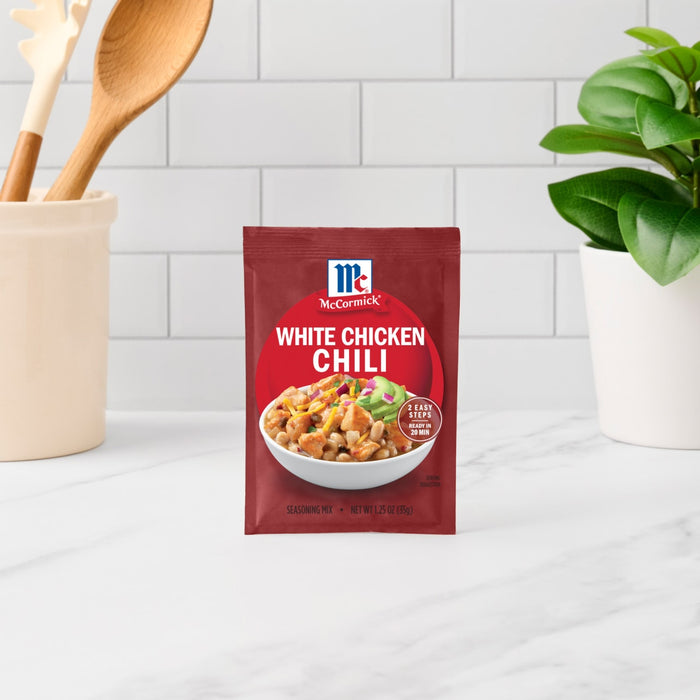 A packet of McCormick White Chicken Chili seasoning mix sits on a kitchen counter.