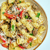 A bowl of pasta with ground beef, red peppers, and parmesan cheese.