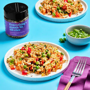 A bowl of Everything's Gonna Be All-Rice seasoning next to a plate of fried rice with vegetables.
