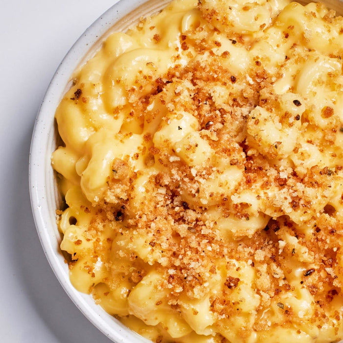 A bowl of macaroni and cheese with a crispy breadcrumb topping.