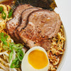 A bowl of ramen with pork, noodles, green onions, bean sprouts, and a soft-boiled egg.