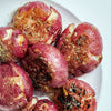 A plate of roasted red potatoes with herbs and spices.