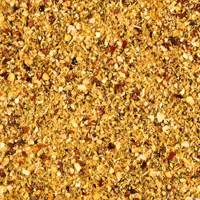 A close-up shot reveals a vibrant blend of dried herbs and spices, creating a textured and aromatic composition.