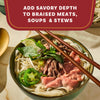 A bowl of Vietnamese pho with beef and fresh herbs demonstrates how a product like Mccormick Gourmet, 0.42 Oz can add savory depth to soups and stews.