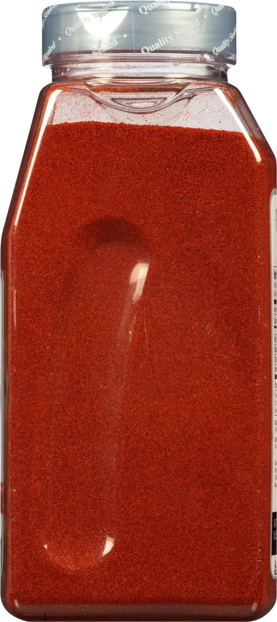 A clear plastic jar filled with red chili powder.