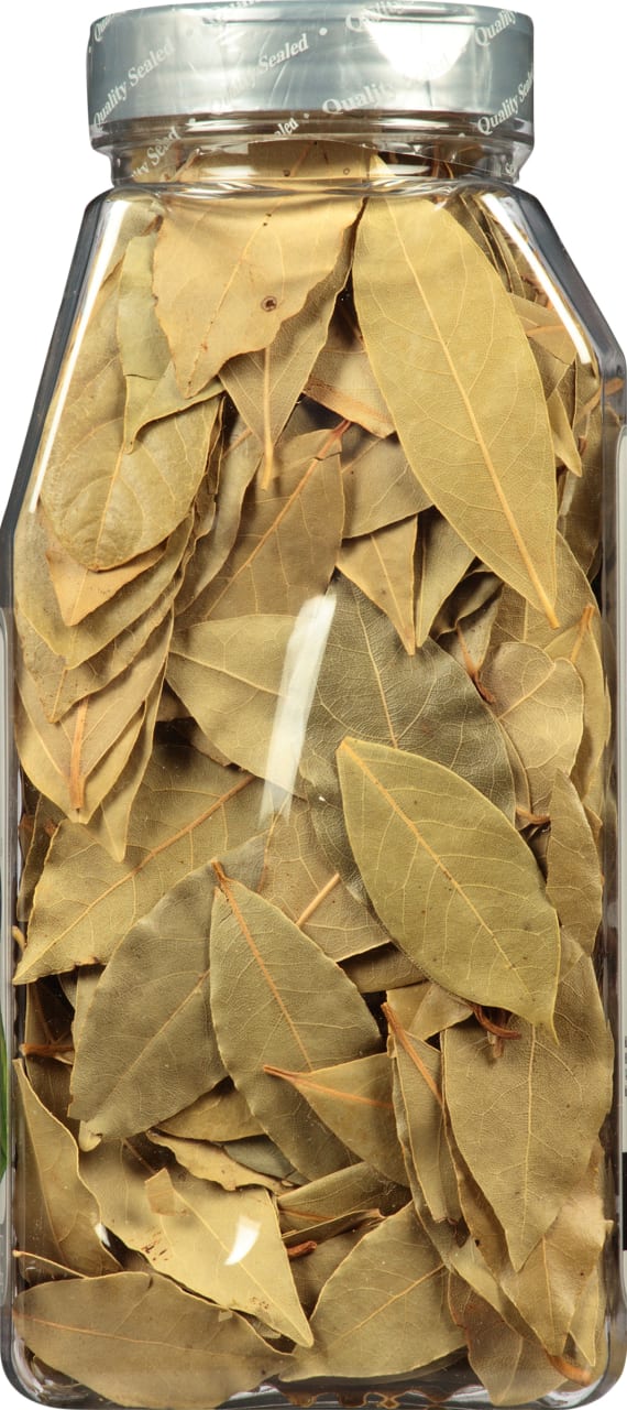 A glass jar filled with dried bay leaves.