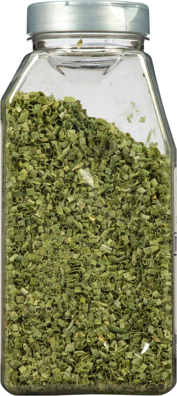 A clear plastic jar filled with dried chives.