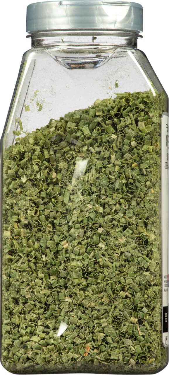 A clear plastic jar filled with dried chives.
