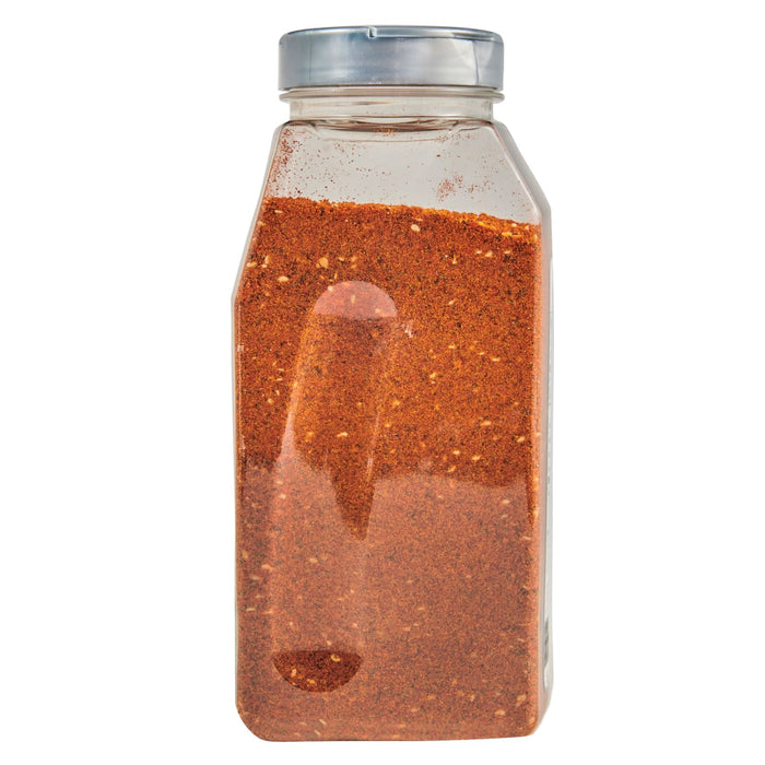 A clear plastic bottle filled with a red and orange spice blend.