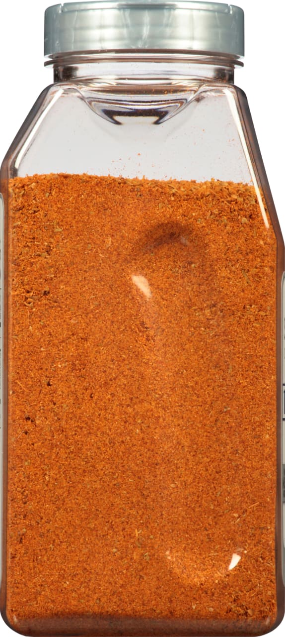 A glass jar filled with a red and orange spice blend.