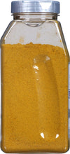 A glass jar filled with yellow curry powder.