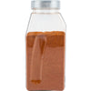 A clear plastic container filled with a reddish-brown spice likely paprika or chili powder with a silver lid.