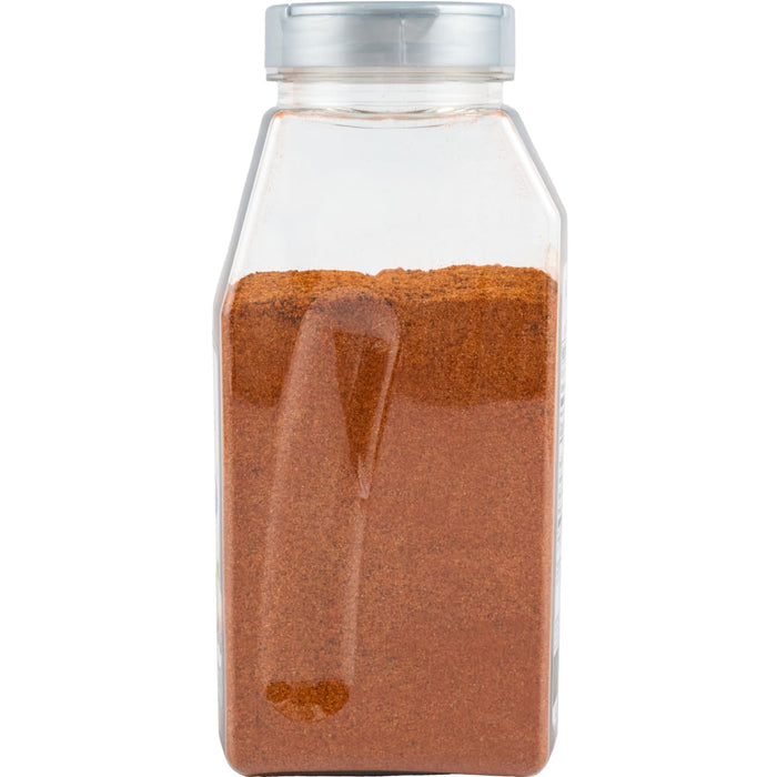 A clear plastic container filled with a reddish-brown spice likely paprika or chili powder with a silver lid.