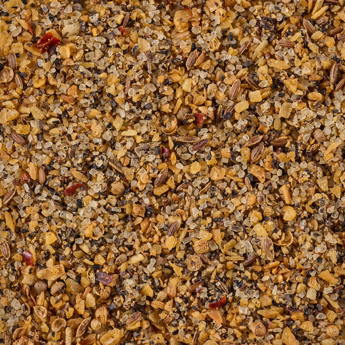 A close-up of a blend of spices, including salt, pepper, garlic, and red pepper flakes.