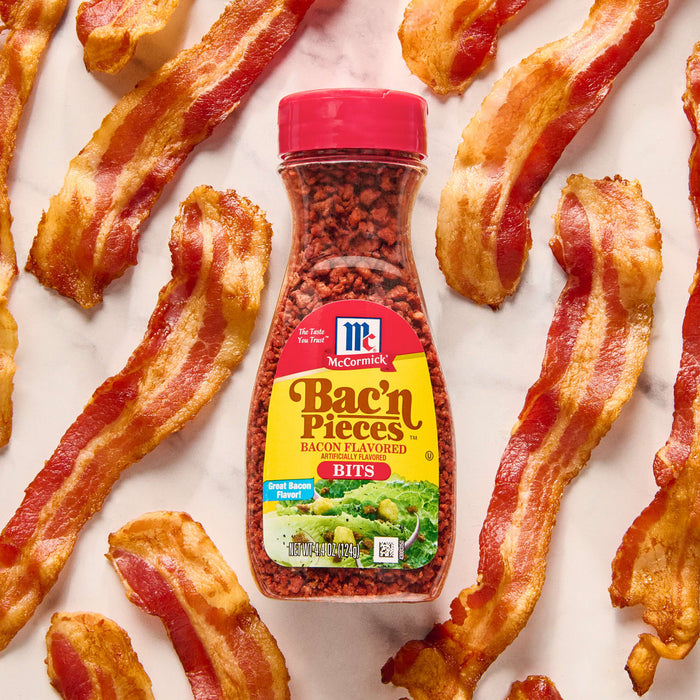 A jar of McCormick Bac'n Pieces Bacon Flavored Bits is surrounded by crispy cooked bacon.