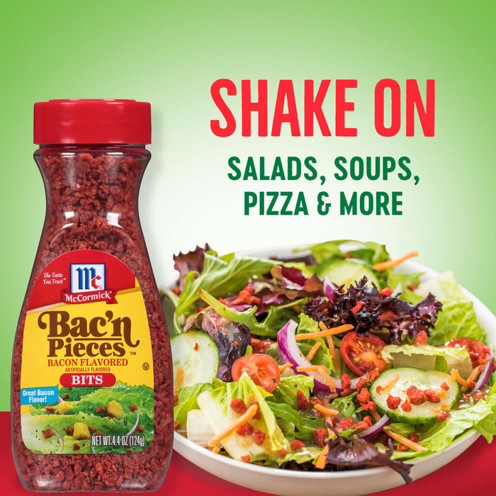 A jar of McCormick Bac'n Pieces bacon bits is shown next to a bowl of salad with the bacon bits sprinkled on top.