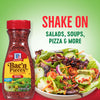 A jar of McCormick Bac'n Pieces bacon bits is shown next to a bowl of salad with the bacon bits sprinkled on top.
