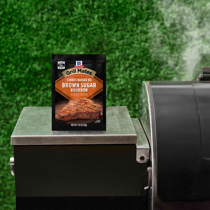 A packet of McCormick Grill Mates Brown Sugar Bourbon seasoning sits on a grill.