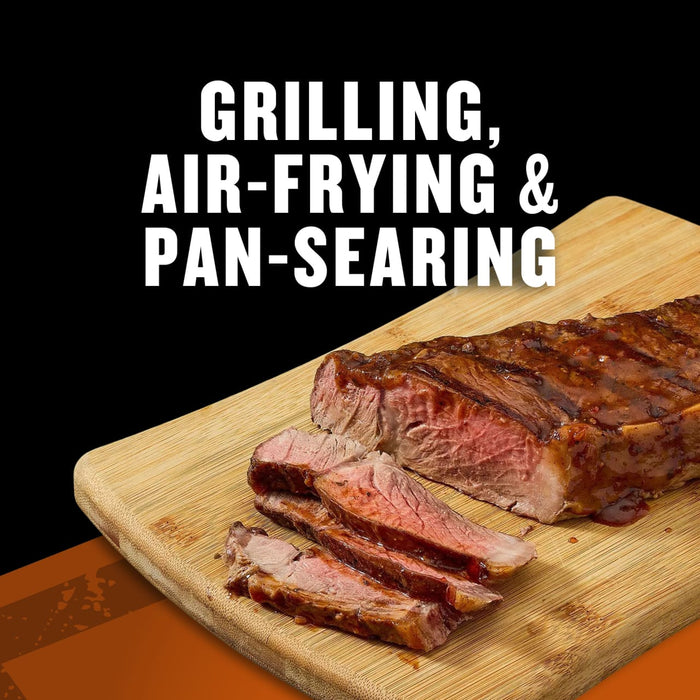A juicy steak cooked using grilling, air-frying, and pan-searing methods is displayed on a wooden cutting board.
