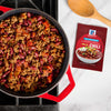 A pot of chili made with McCormick Chili seasoning mix is shown next to the seasoning packet.