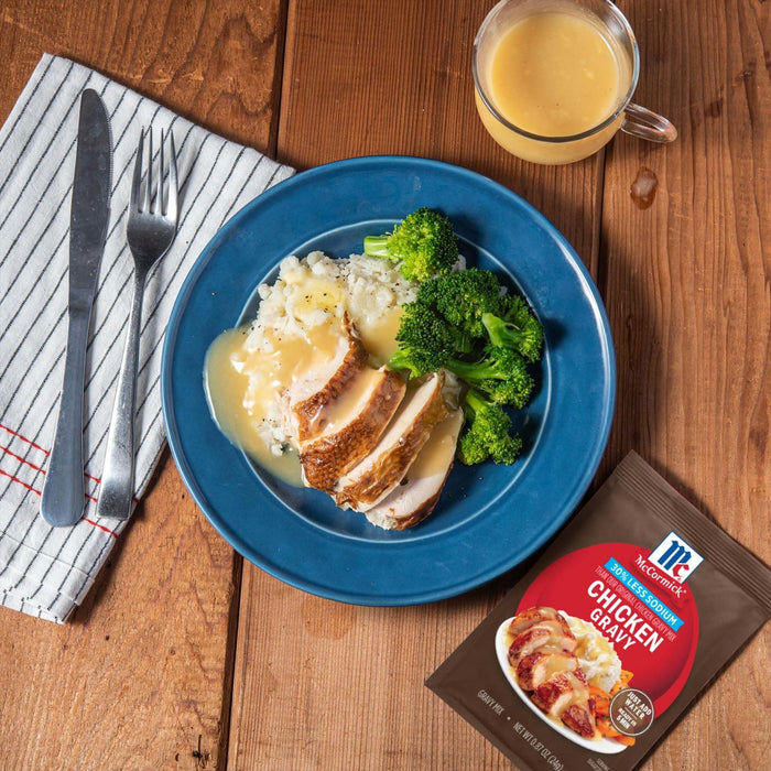 A prepared meal featuring McCormick Chicken Gravy mix served with chicken, mashed potatoes, and broccoli.