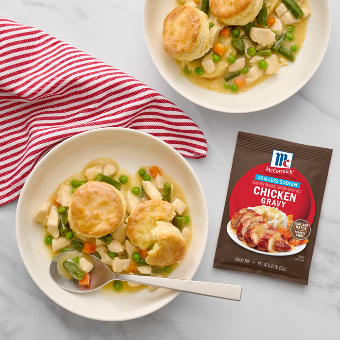 Two plates of chicken pot pie made with McCormick Chicken Gravy mix are displayed with a red and white striped towel.