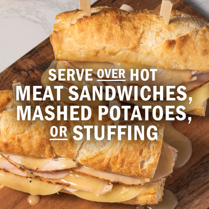 A close-up of a hot meat sandwich with melted cheese and gravy, suggesting it can be served over mashed potatoes or stuffing.