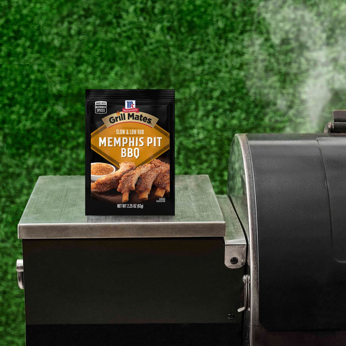 A packet of McCormick Slow Cookers Memphis Pit BBQ seasoning mix sits on a grill.