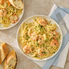 A close up view of restaurant style scampi featuring linguine pasta and shrimp prepared with Mccormick Garlic Butter Shrimp Scampi Seasoning Mix .87 Oz and topped with fresh parsley and parmesan cheese.
