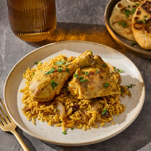 A plate of flavorful chicken and rice dish, accompanied by naan bread, suggesting a delicious and satisfying meal.