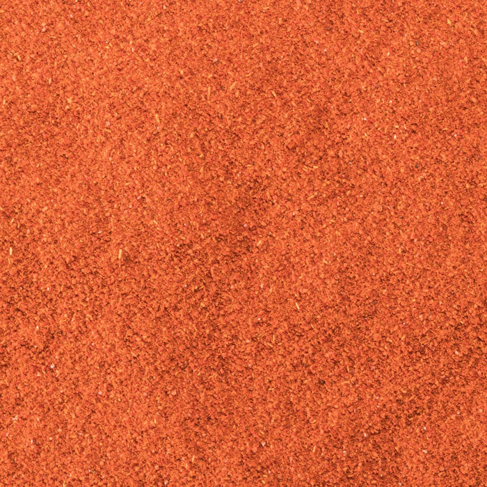 A close-up texture of vibrant orange-red chili powder.