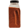 A glass jar filled with a red spice blend.
