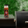 A bottle of McCormick Grill Mates Montreal Steak Seasoning sits next to a grill.