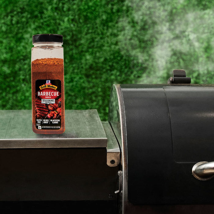 A bottle of McCormick Grill Mates Montreal Steak Seasoning sits next to a grill.