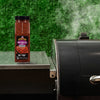 A jar of Pit Boss Smoked Chili Flakes sits next to a grill, suggesting its use in outdoor cooking.
