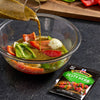 A bowl of vegetables is being marinated with McCormick Zesty Herb marinade.