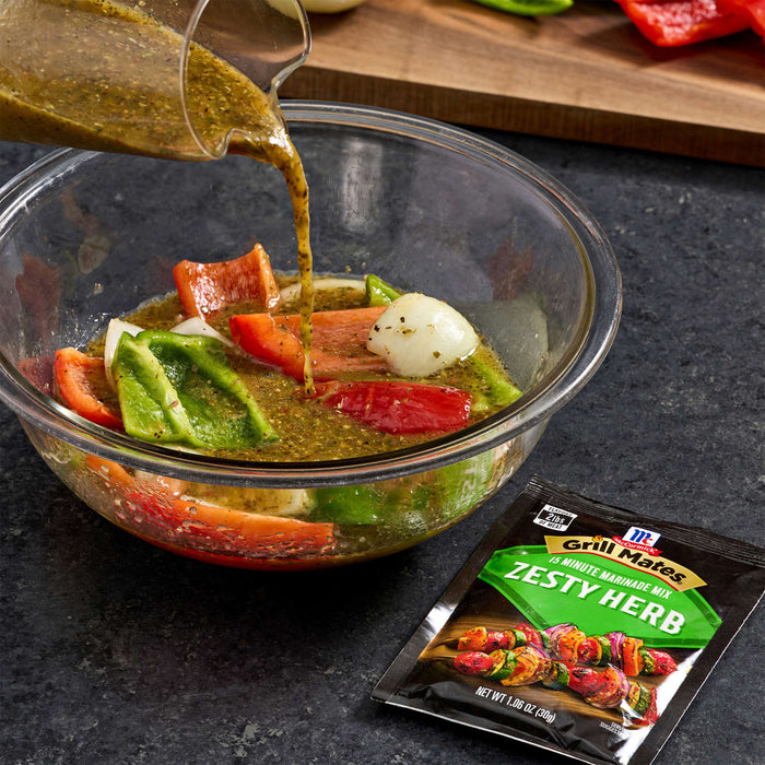 A bowl of vegetables is being marinated with McCormick Zesty Herb marinade.