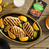 Grilled chicken breasts seasoned with McCormick Zesty Herb marinade mix are arranged on a platter with grilled lemon and lime wedges.