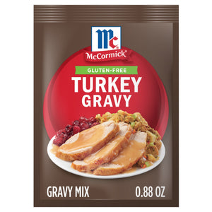 A package of Mccormick Turkey Gravy Gluten Free mix, featuring a plate of sliced turkey with gravy, cranberry sauce, and stuffing.