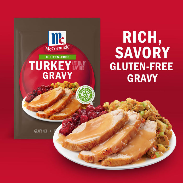 A packet of McCormick Gluten-Free Turkey Gravy mix is displayed next to a plate of turkey, cranberry sauce, and stuffing, highlighting the rich, savory flavor of the gravy.