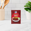 A packet of McCormick Chili seasoning mix sits on a kitchen counter.