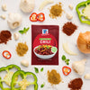 McCormick Chili seasoning packet surrounded by fresh ingredients like garlic, peppers, and spices.